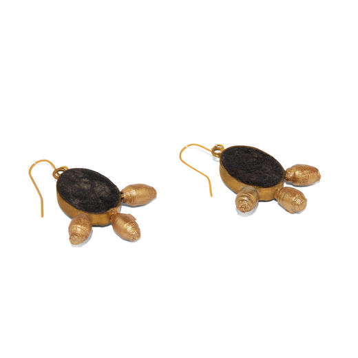 A pair of black oval hook earring with three pendants each, lying on a white surface.